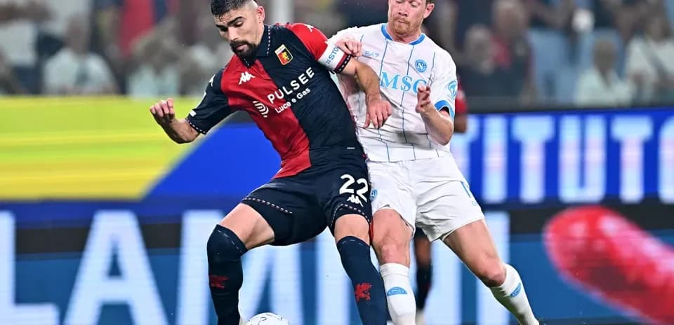 Genoa player battling Napoli player for possession