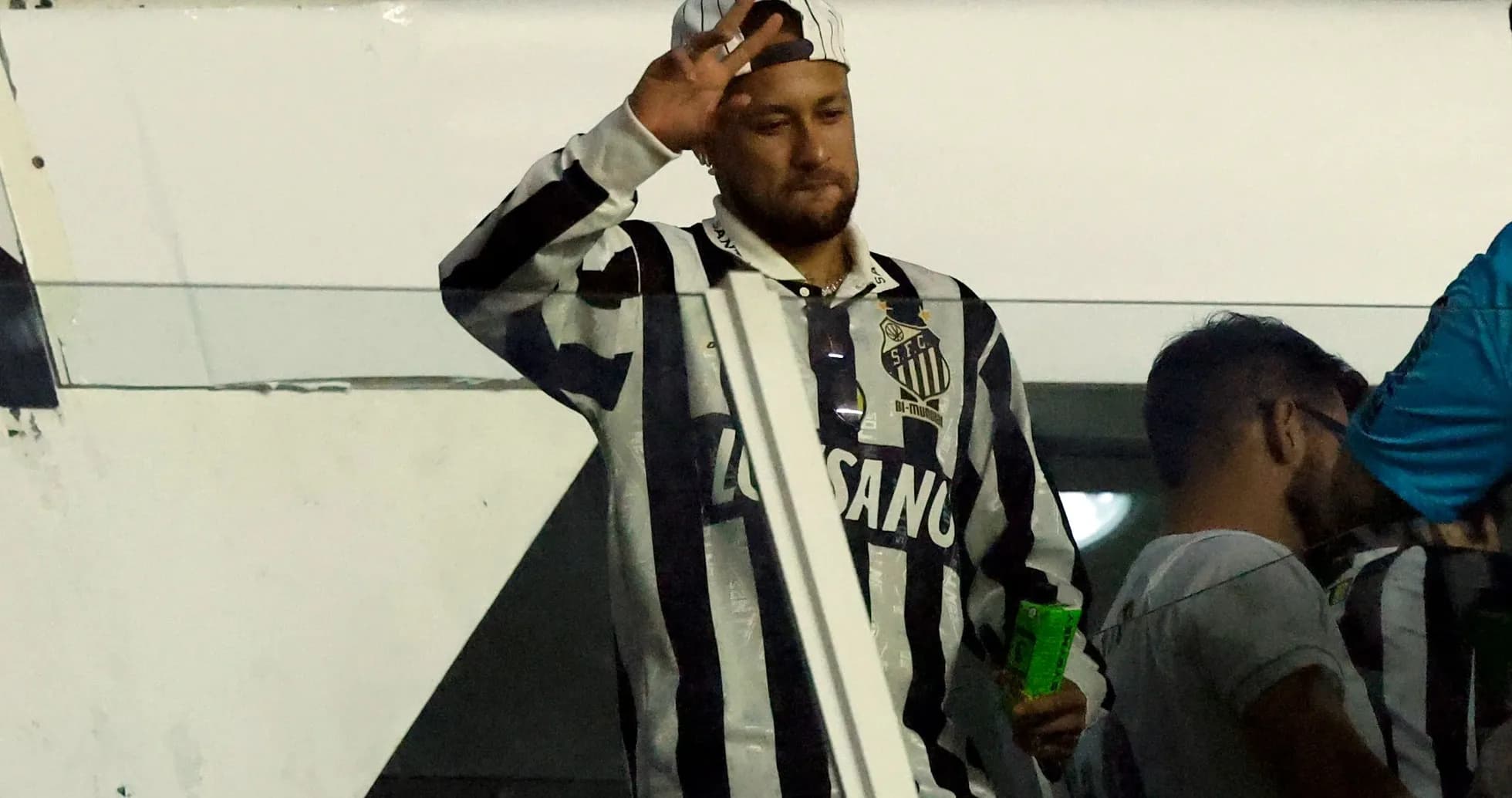Fan waving while wearing Santos FC jersey