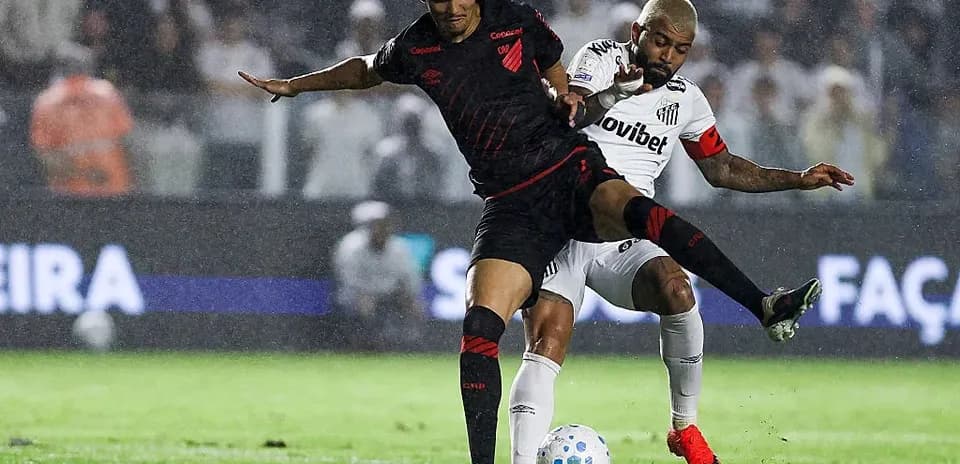 Players battling for possession during a rainy match