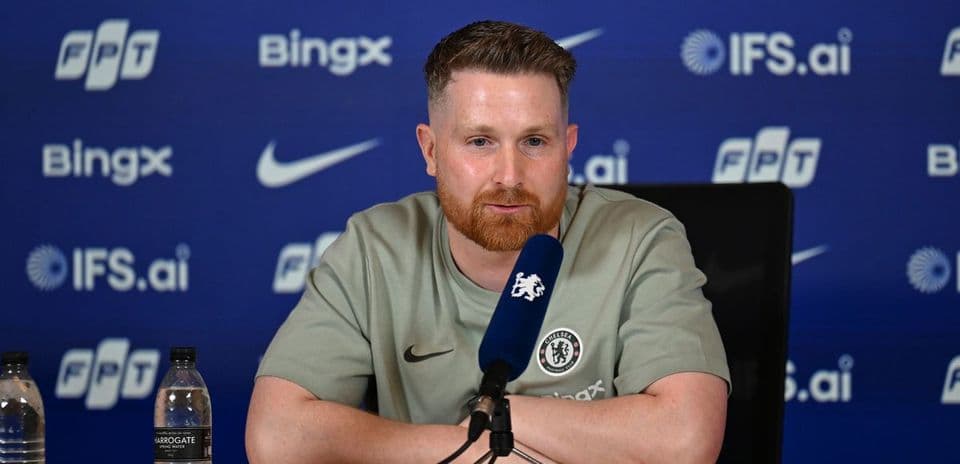 Manager speaking at press conference with Chelsea branding
