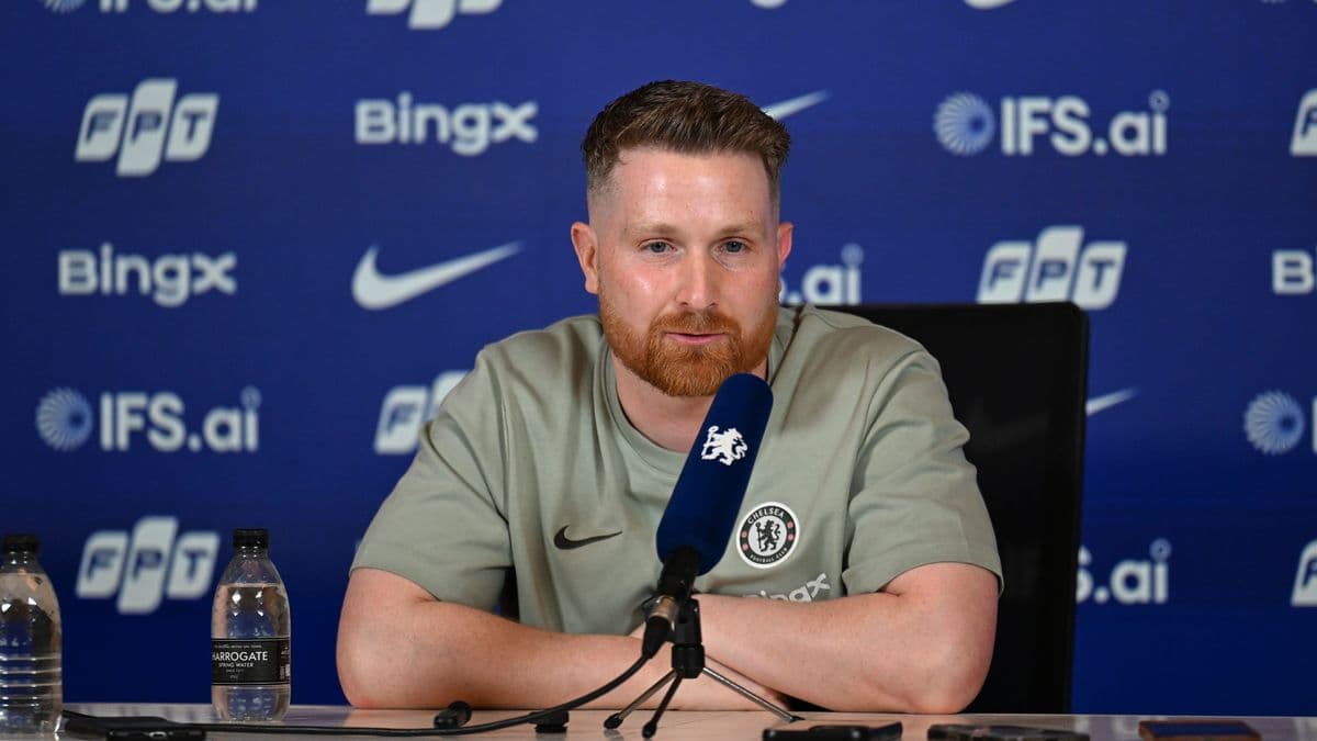 Manager speaking at press conference with Chelsea branding