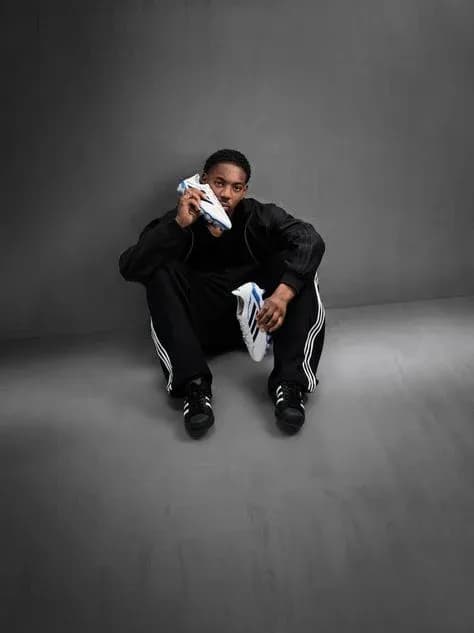 Athlete sitting with soccer shoe in hand