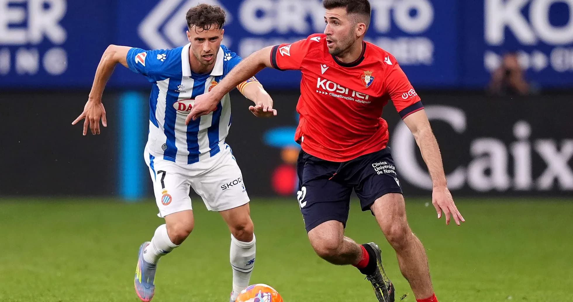 Osasuna player racing against Espanyol opponent
