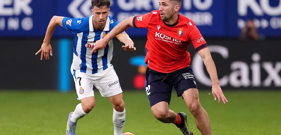 Osasuna player racing against Espanyol opponent