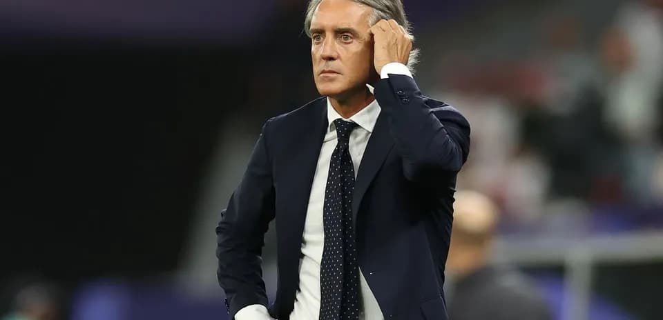 Coach observing the match with a thoughtful expression