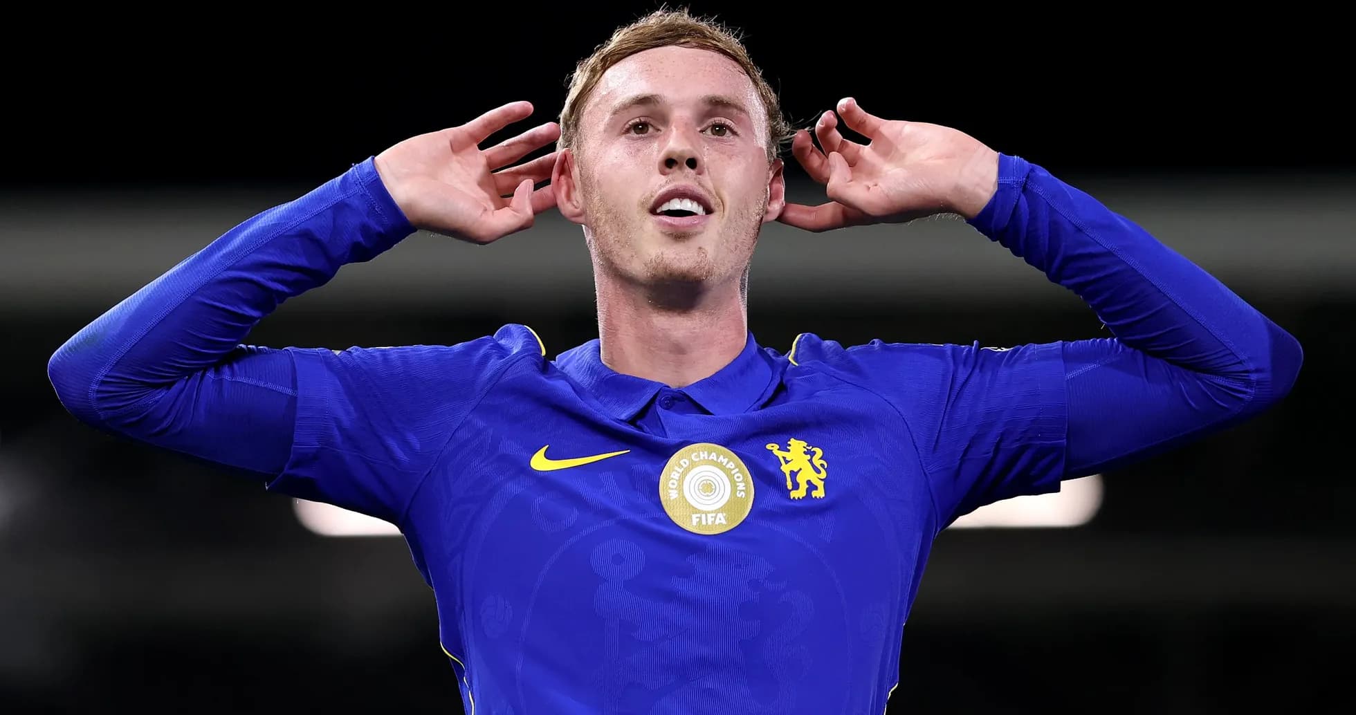 Player celebrating with hands behind ears in blue jersey