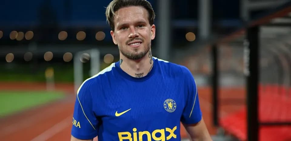 Player in blue Chelsea jersey smiling on pitch