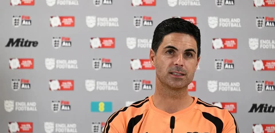 Manager speaking at press conference with logos backdrop