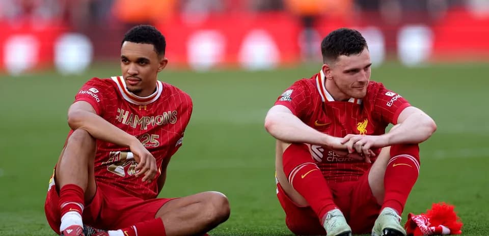 Two Liverpool players sitting on the pitch post-match
