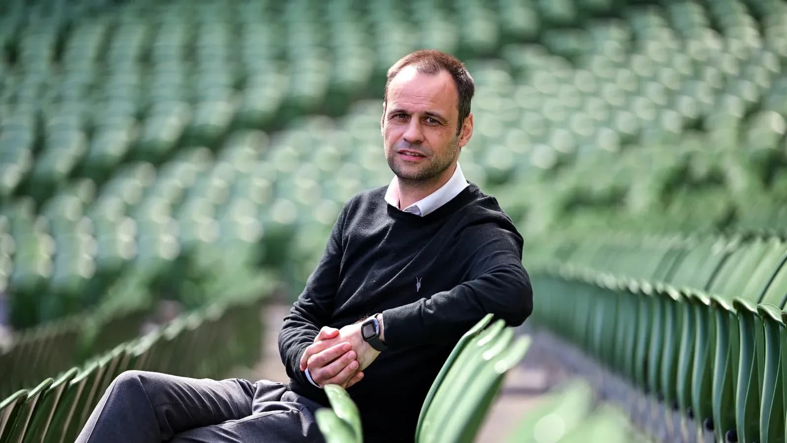 Person sitting on empty stadium seats