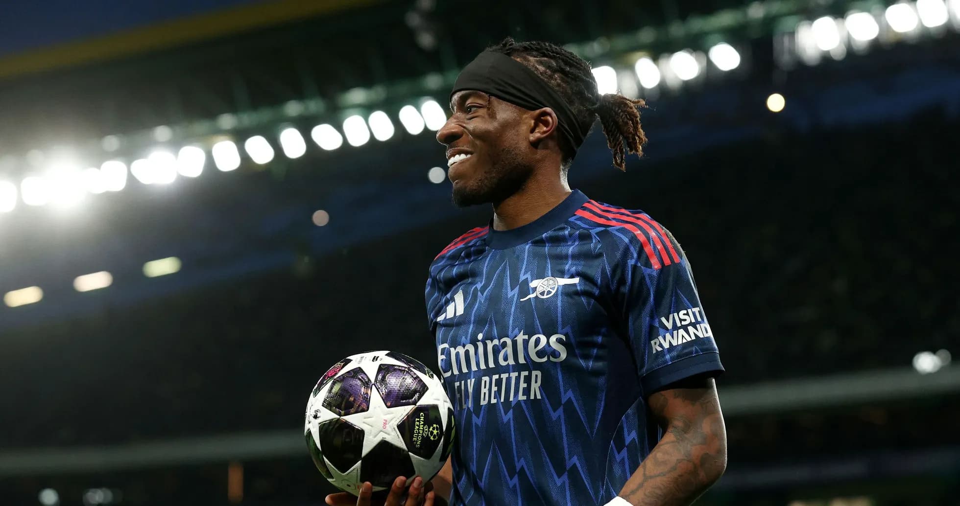 Player holding a UEFA Champions League ball on field