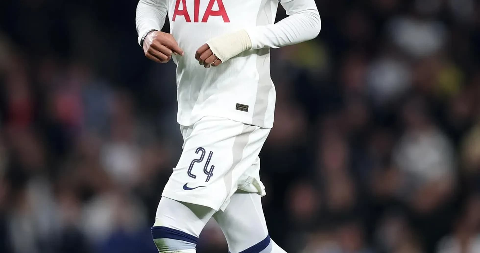 Player in Tottenham kit dribbling ball on pitch