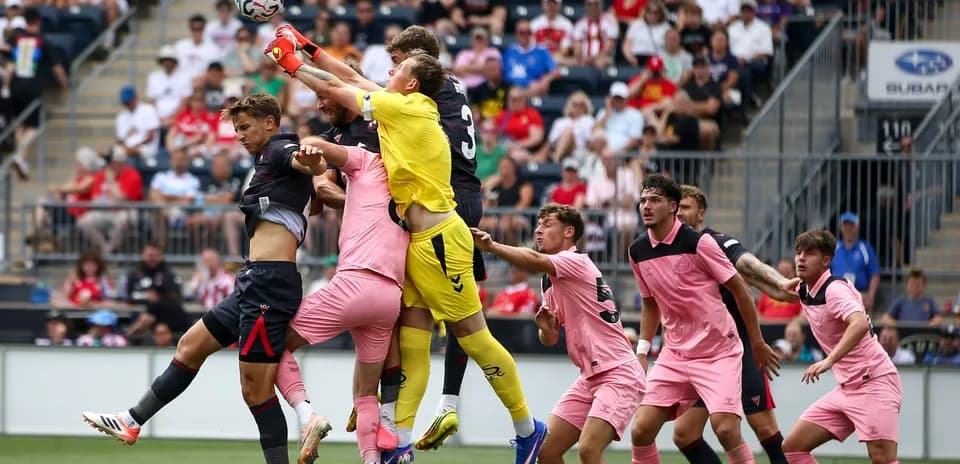 Goalkeeper jumping to catch the ball during match
