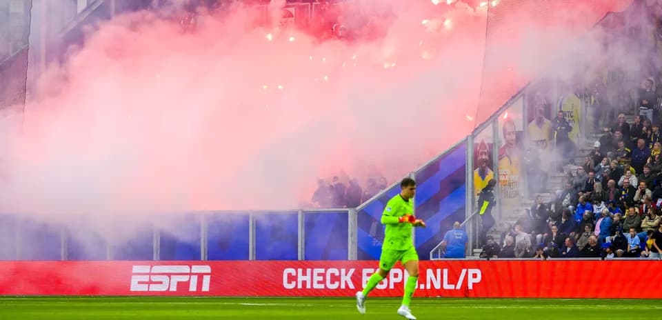 Goalkeeper walking past smoke during match celebration