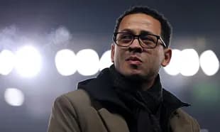 Man in glasses standing under stadium lights