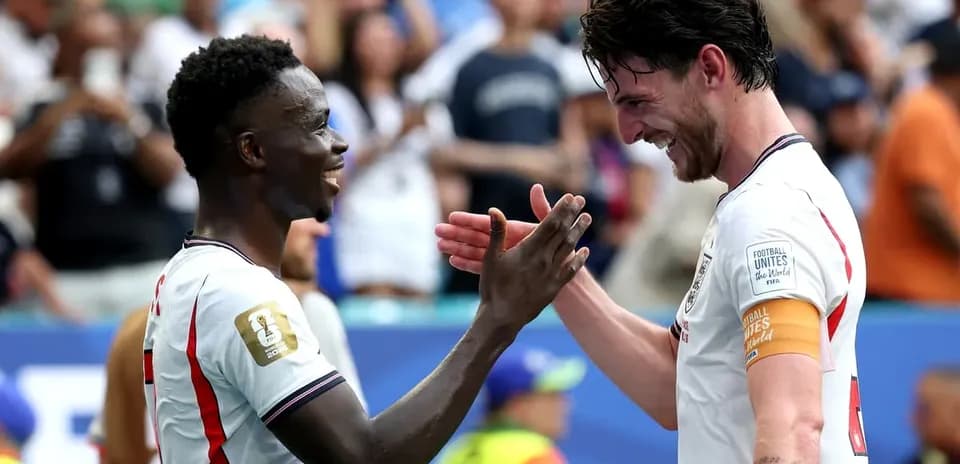 Two players celebrating with a handshake on field