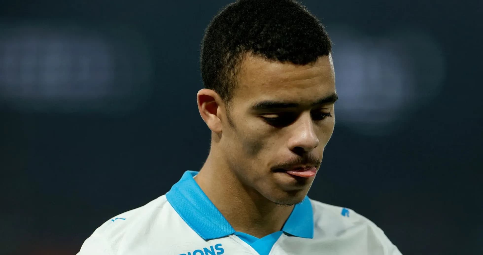 Player in white jersey looking down thoughtfully Player in white jersey looking down thoughtfully