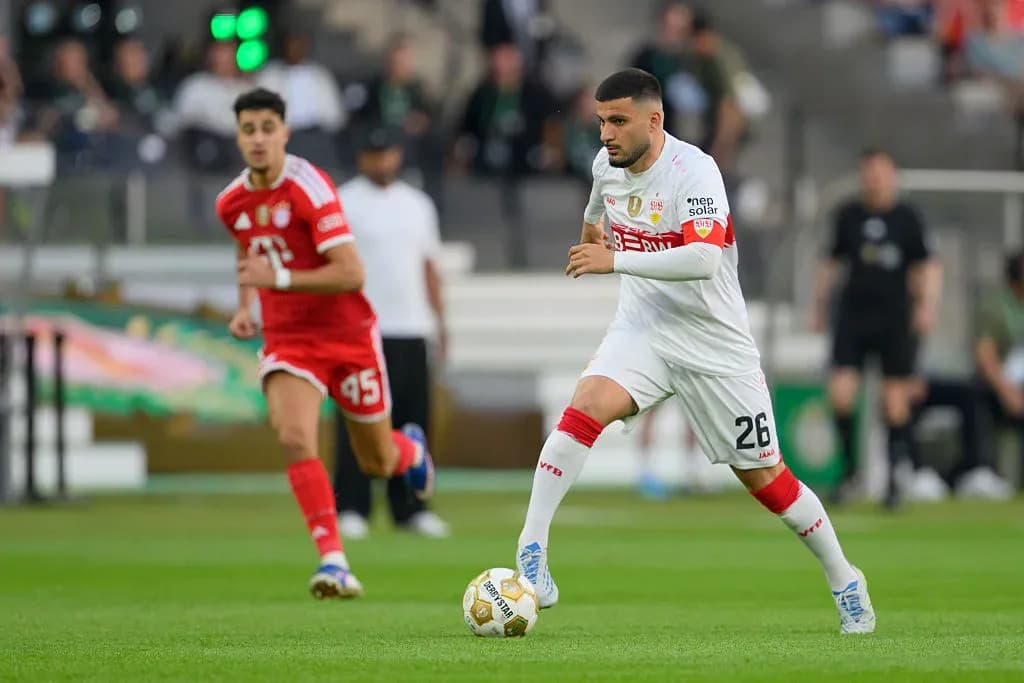 Player dribbling the ball during a football match Player dribbling the ball during a football match