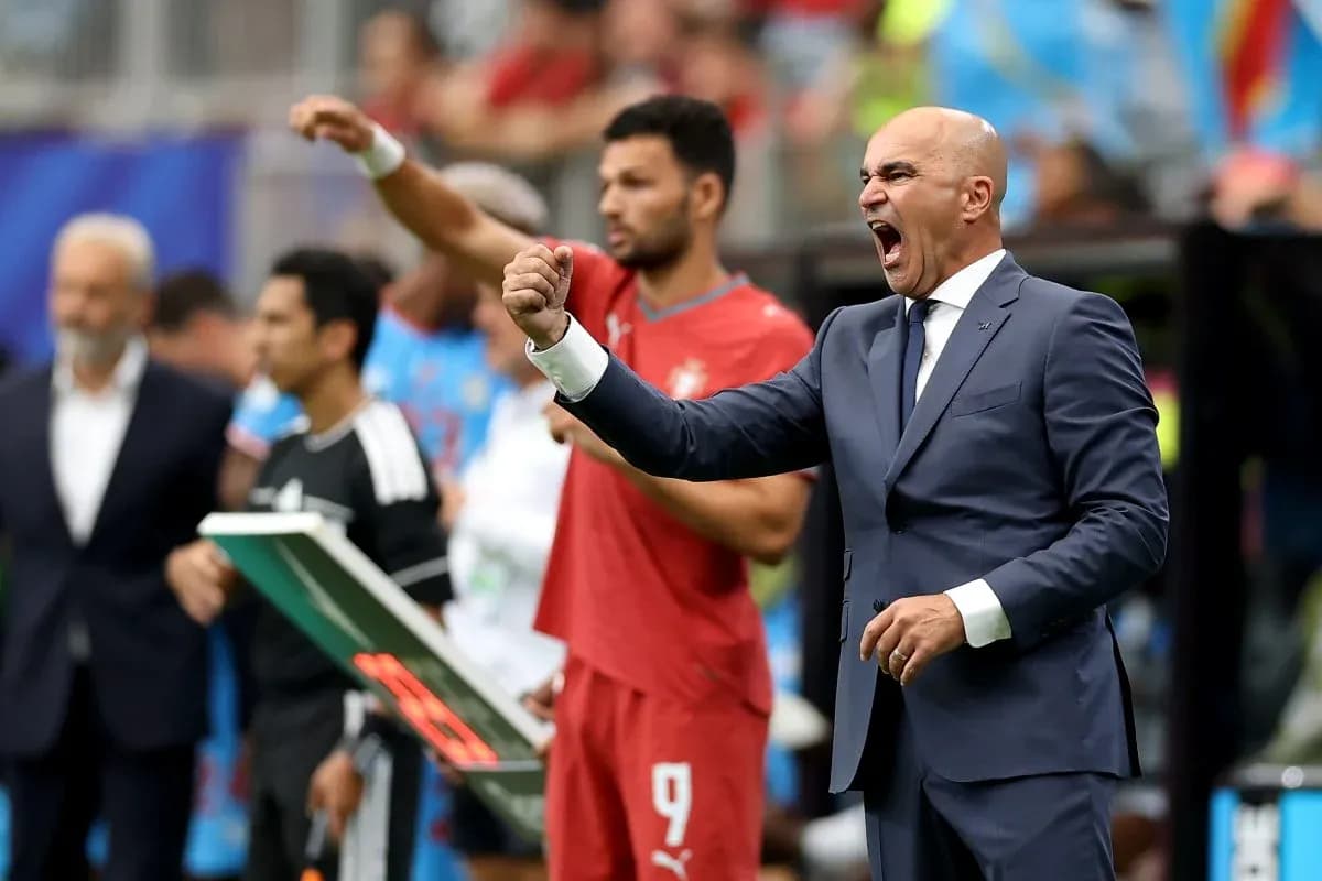 Coach celebrating while players stand on sidelines Coach celebrating while players stand on sidelines