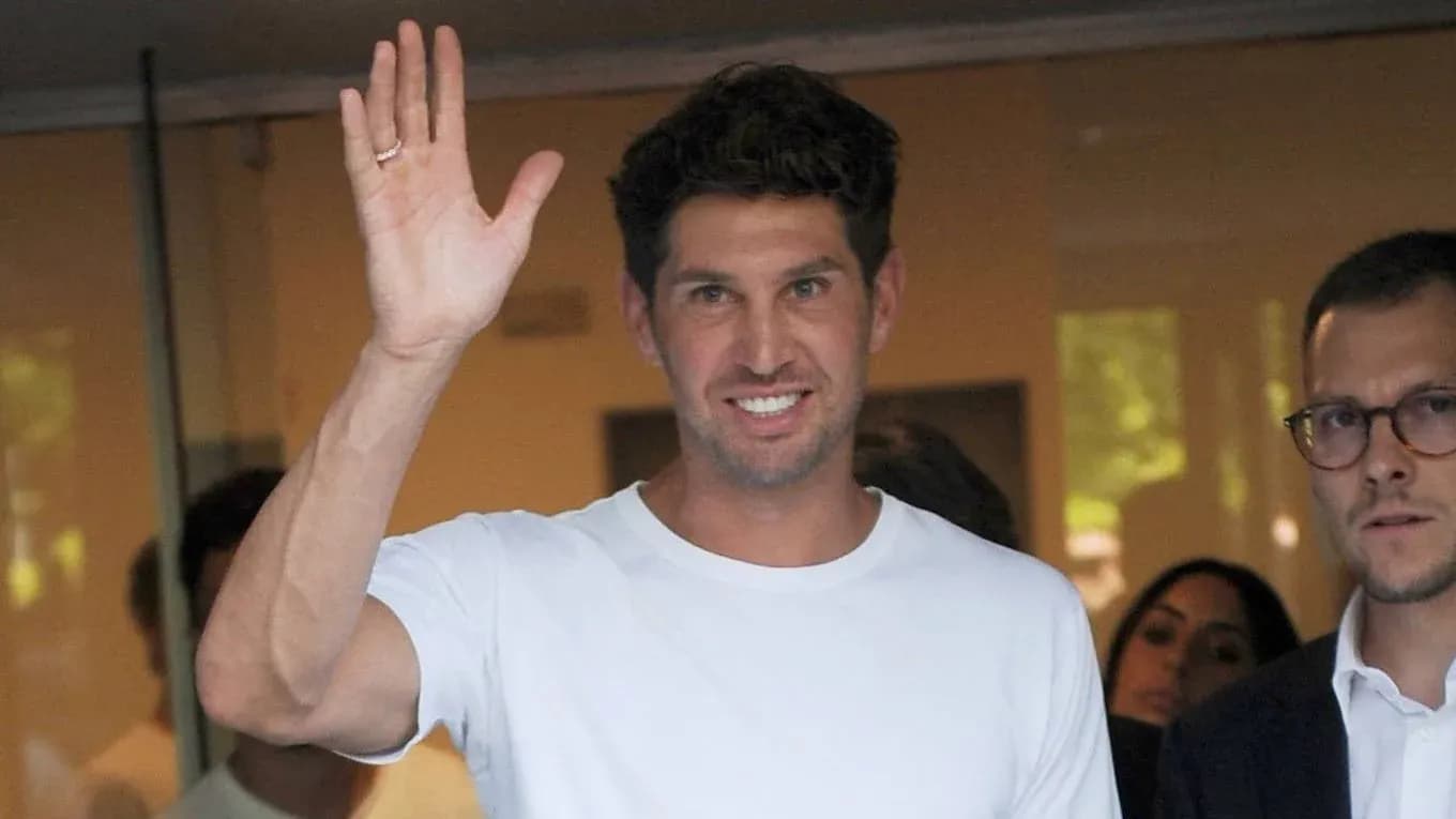 Man in white shirt waving, surrounded by people Man in white shirt waving, surrounded by people