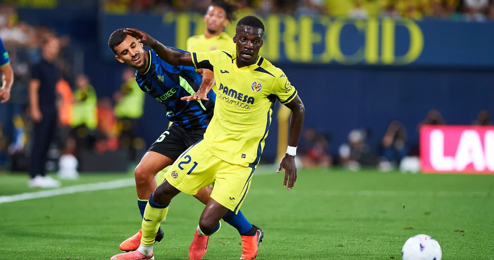 Villarreal player dribbling past opponent during match Villarreal player dribbling past opponent during match