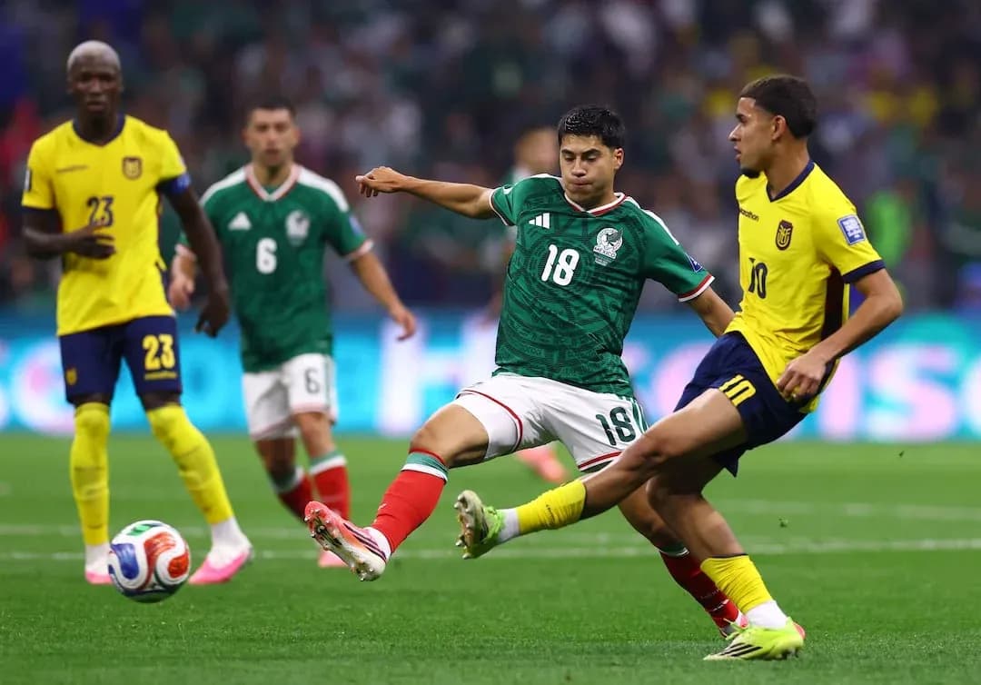 Mexico player tackling Ecuador player during match Mexico player tackling Ecuador player during match