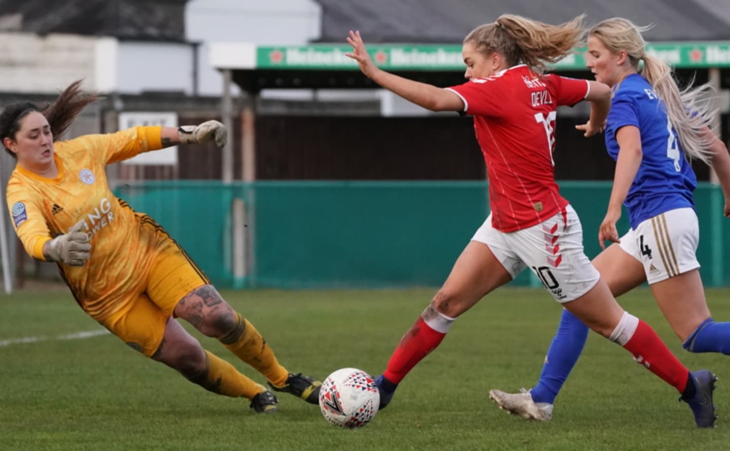 Goalkeeper attempting to save during women's football match Goalkeeper attempting to save during women's football match
