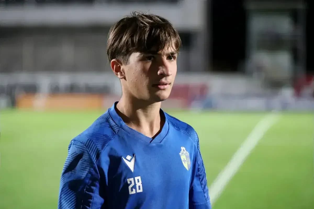 Young player wearing blue jersey on football field Young player wearing blue jersey on football field