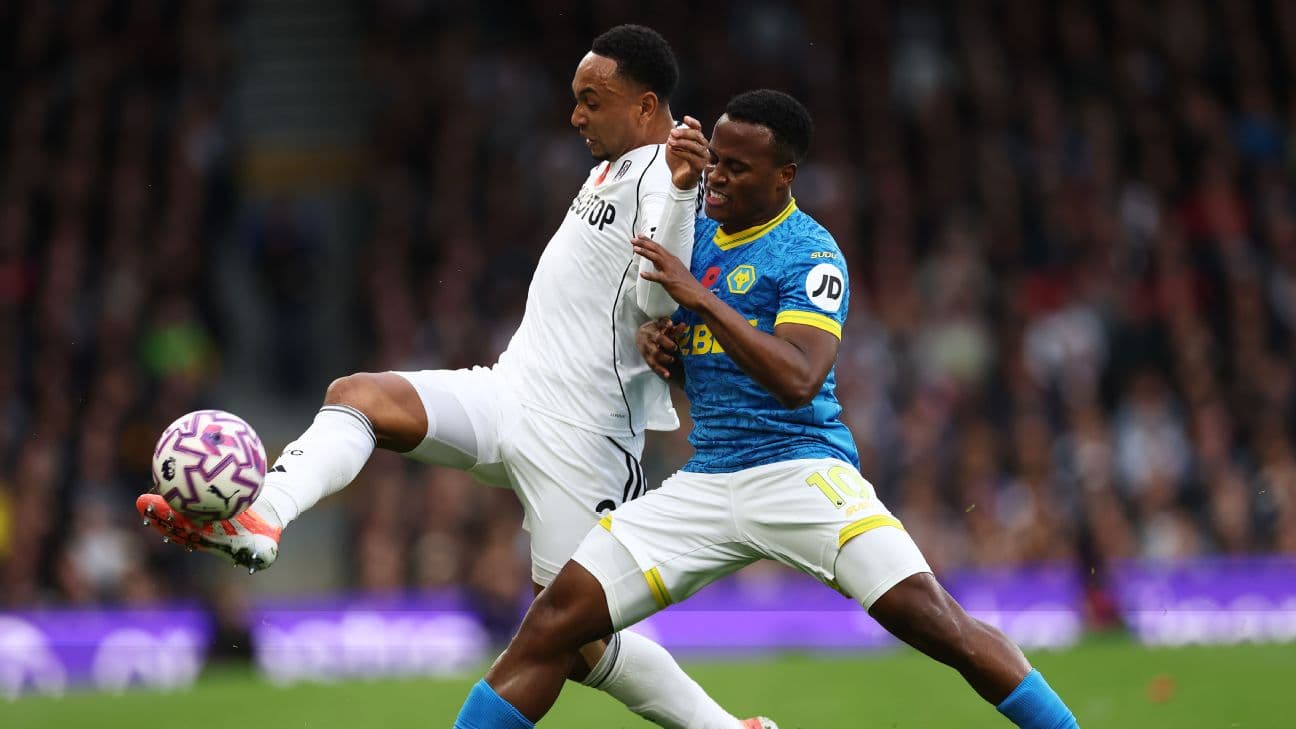 Fulham player challenging Wolves player for the ball Fulham player challenging Wolves player for the ball