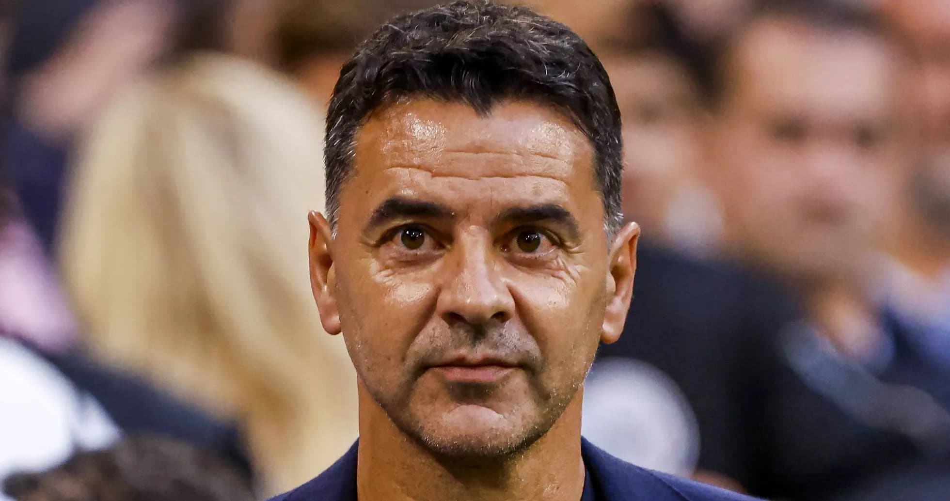 Man in suit at sports event, focused expression Man in suit at sports event, focused expression