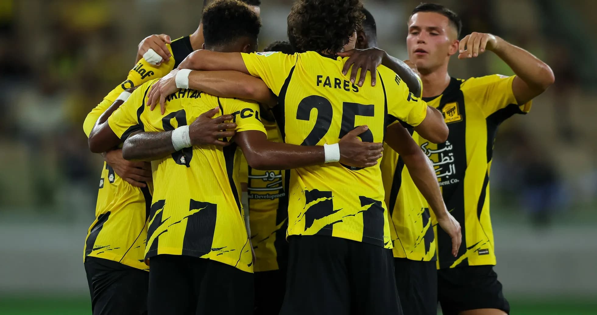 Players celebrating a goal in yellow jerseys Players celebrating a goal in yellow jerseys