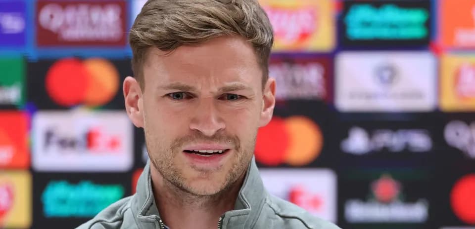 Man speaking at press conference with sponsor logos Man speaking at press conference with sponsor logos