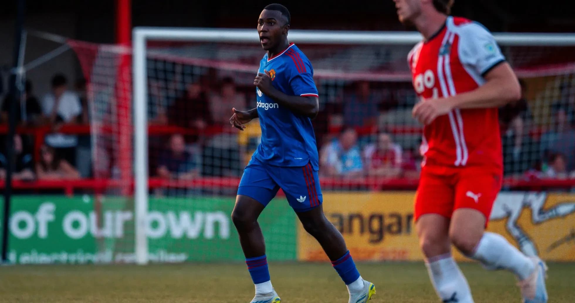 Player in blue kit running on the pitch Player in blue kit running on the pitch