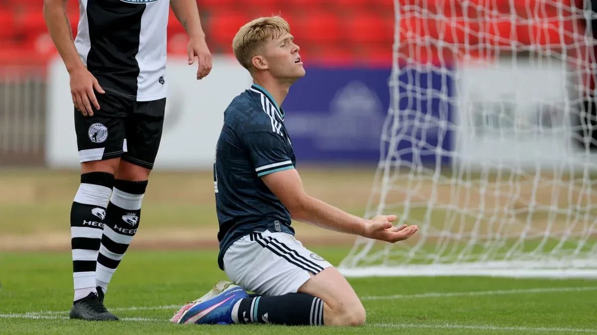 Player kneeling on pitch with hands raised Player kneeling on pitch with hands raised