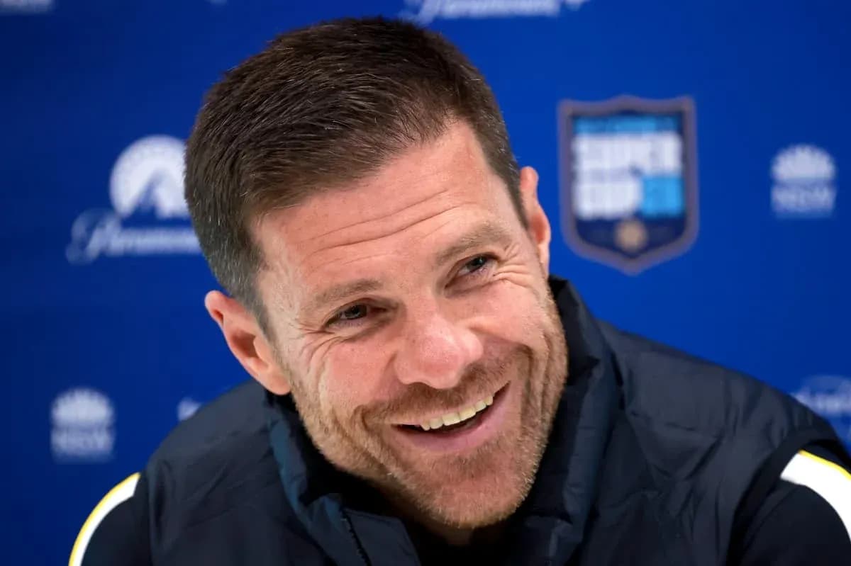 Coach smiling during press conference with backdrop Coach smiling during press conference with backdrop