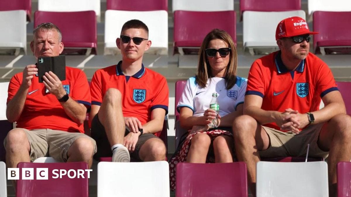 Fans wearing England shirts sitting in stadium seats Fans wearing England shirts sitting in stadium seats