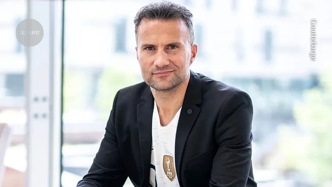 Man in a black blazer sitting indoors Man in a black blazer sitting indoors