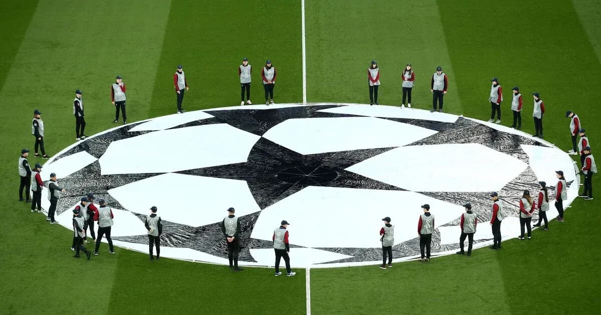 Staff preparing UEFA Champions League logo on field Staff preparing UEFA Champions League logo on field