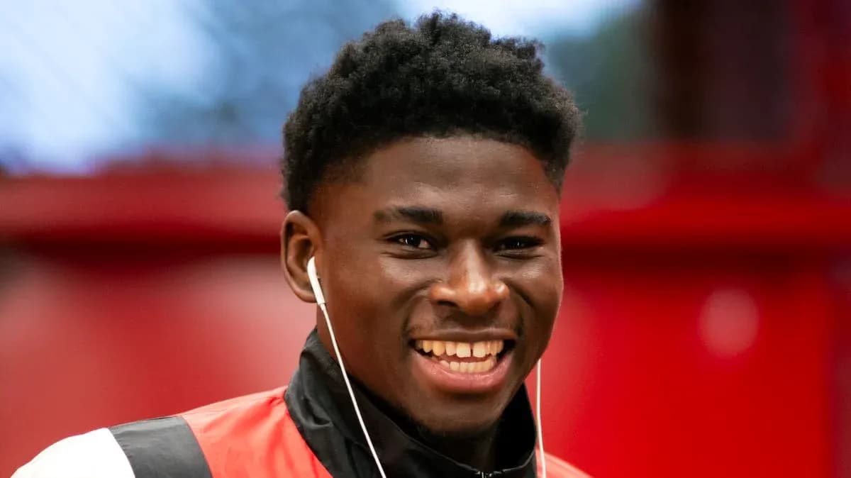 Player smiling while wearing earbuds indoors Player smiling while wearing earbuds indoors