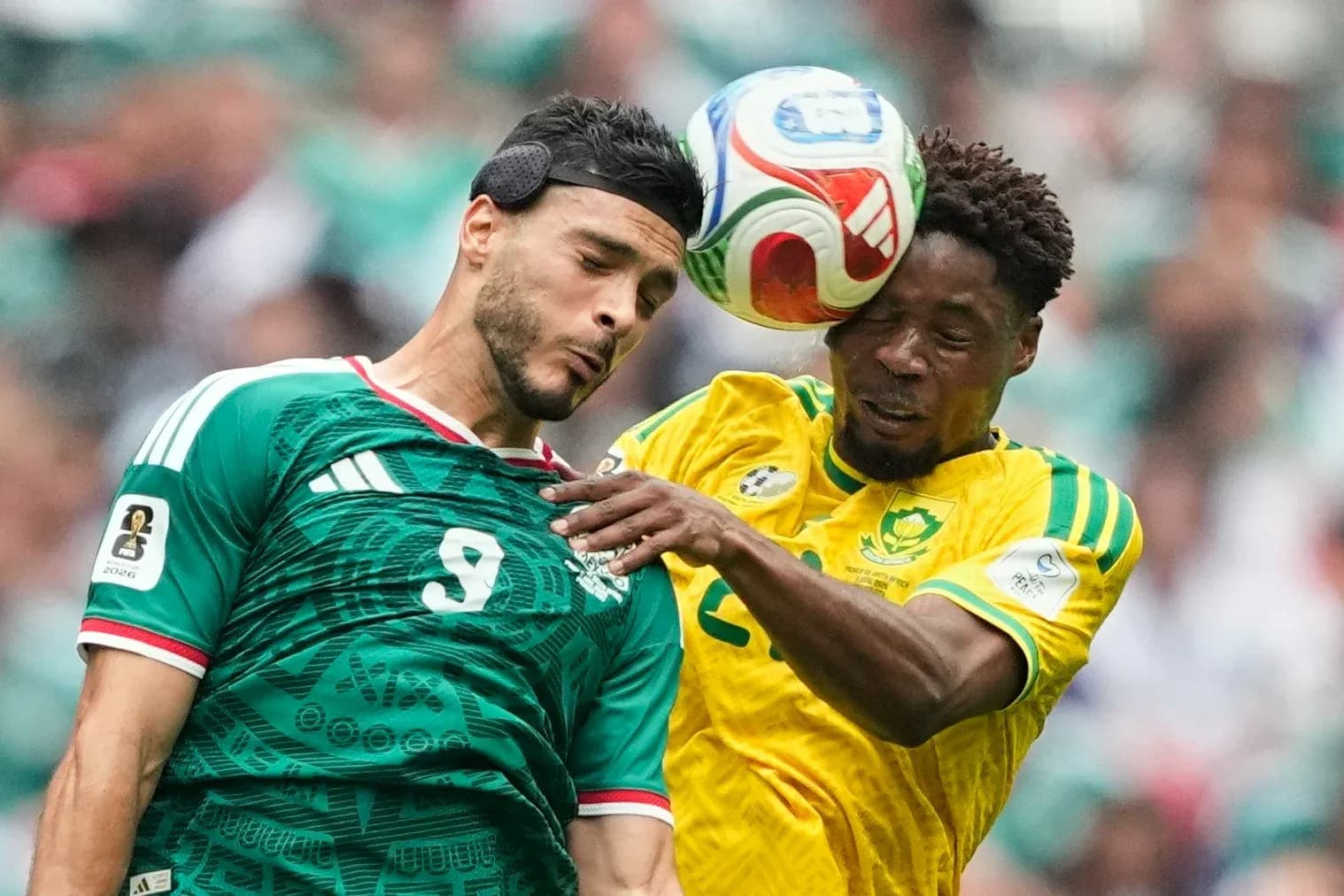 Players from Mexico and South Africa contesting the ball Players from Mexico and South Africa contesting the ball