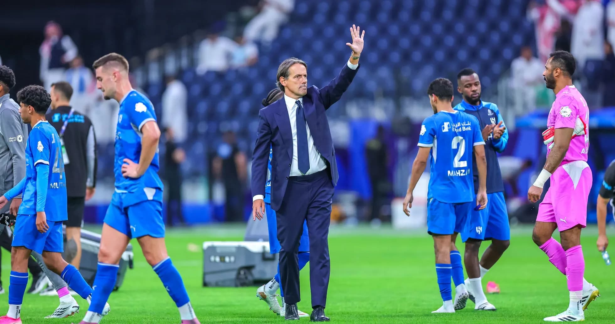 Coach waving as players leave the pitch after match Coach waving as players leave the pitch after match