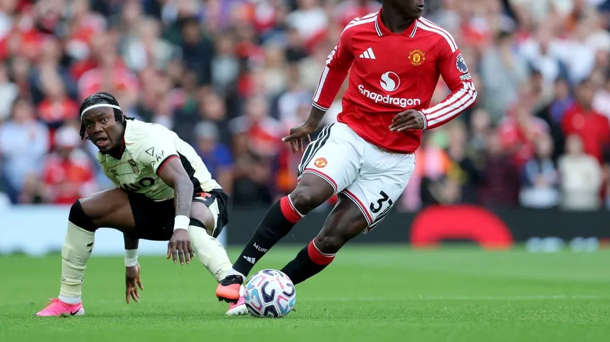 Manchester United player dribbling past opponent on field Manchester United player dribbling past opponent on field