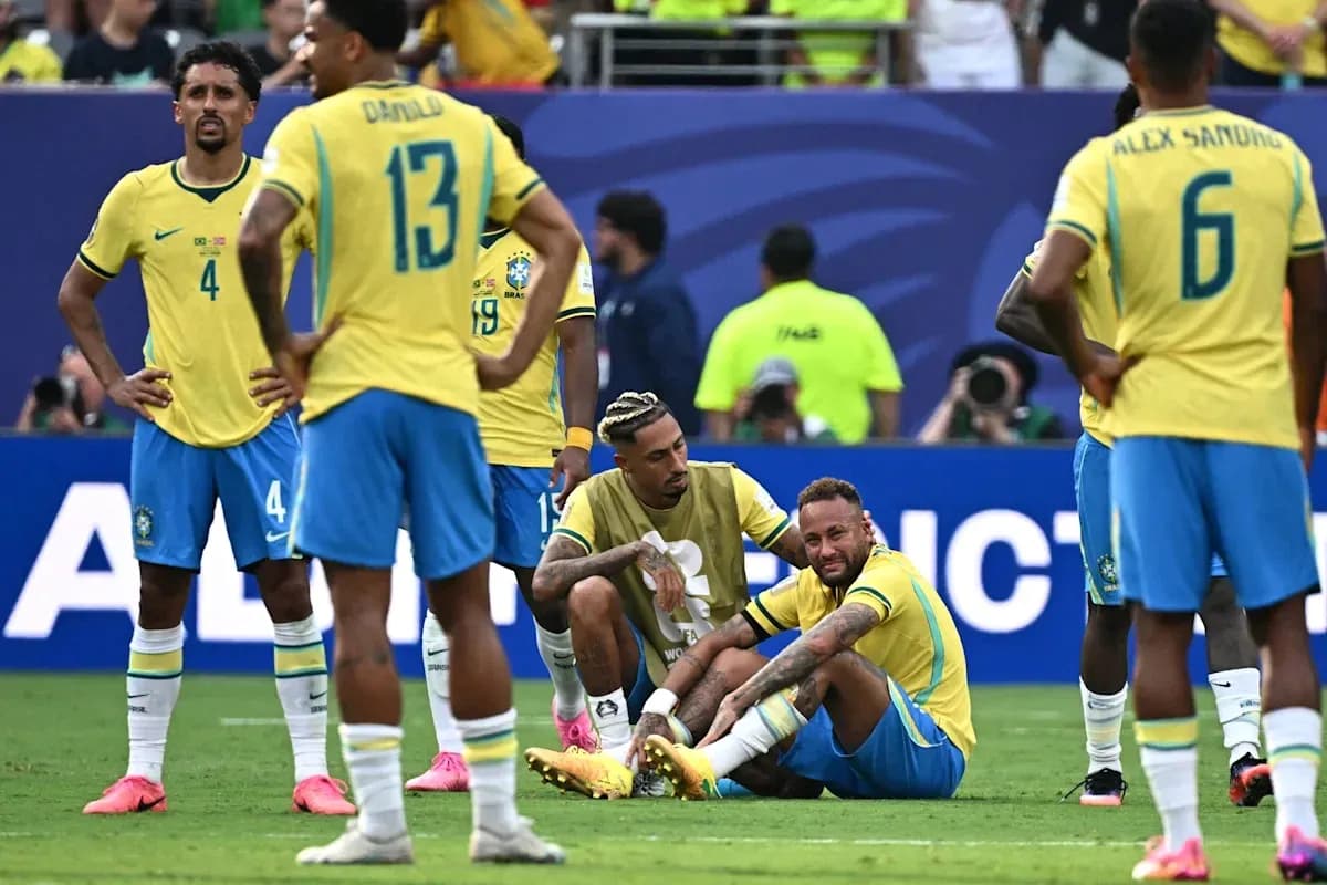 Neymar sitting on the field with teammates nearby Neymar sitting on the field with teammates nearby
