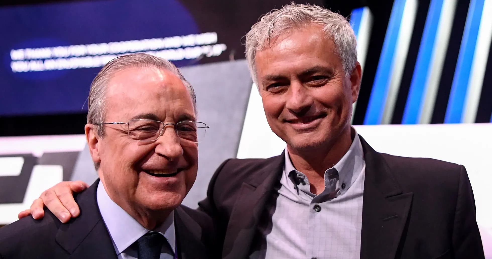 Two men smiling at an event on stage Two men smiling at an event on stage