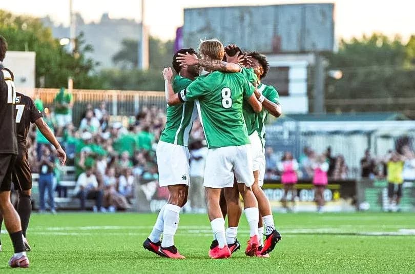 Players celebrating a goal on the field Players celebrating a goal on the field