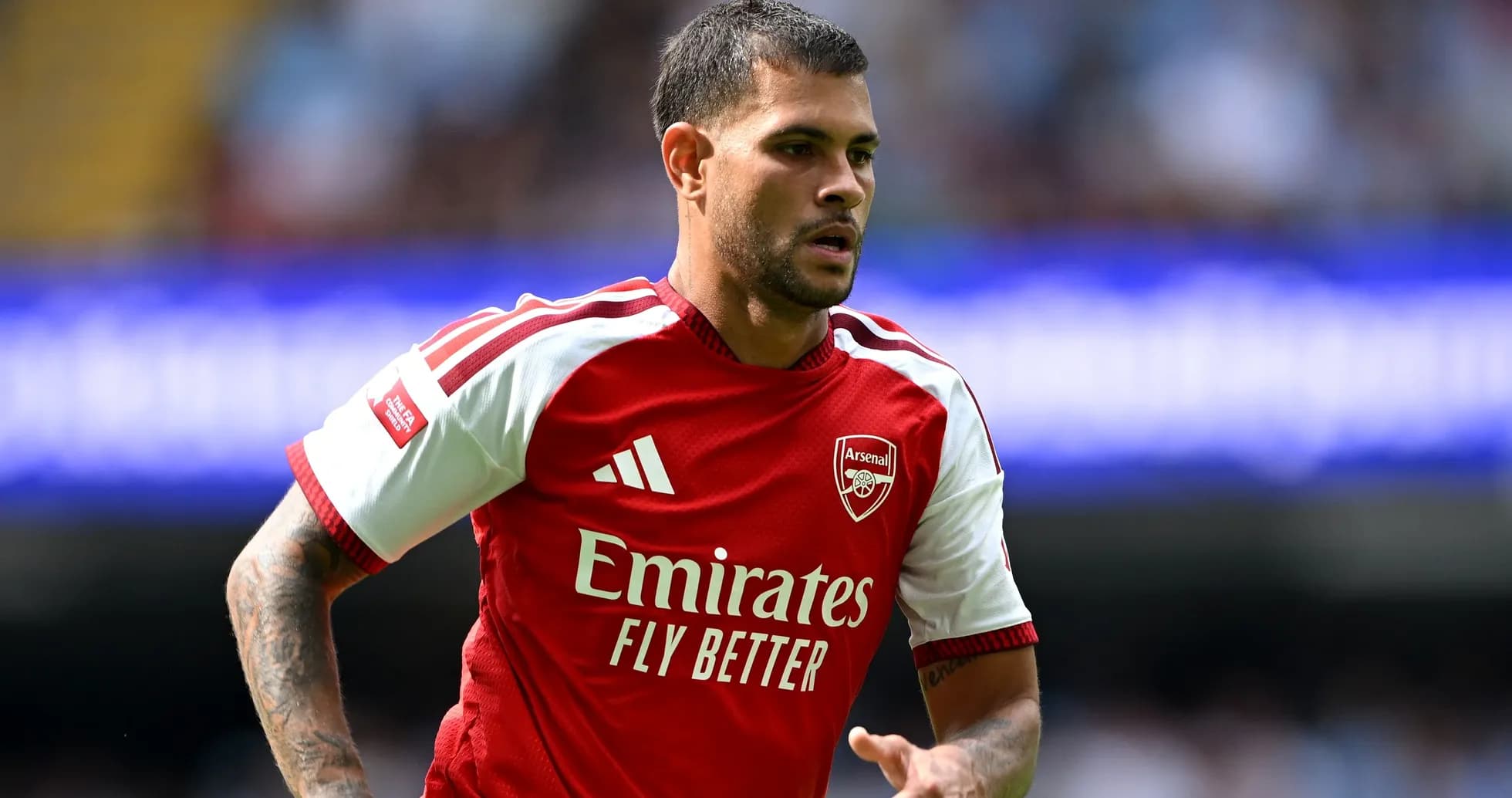 Player in Arsenal jersey running on the field Player in Arsenal jersey running on the field
