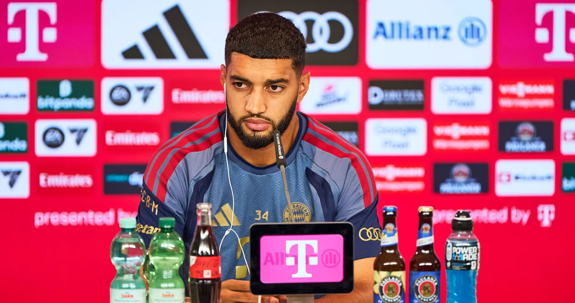 Player speaking at press conference with drinks displayed Player speaking at press conference with drinks displayed
