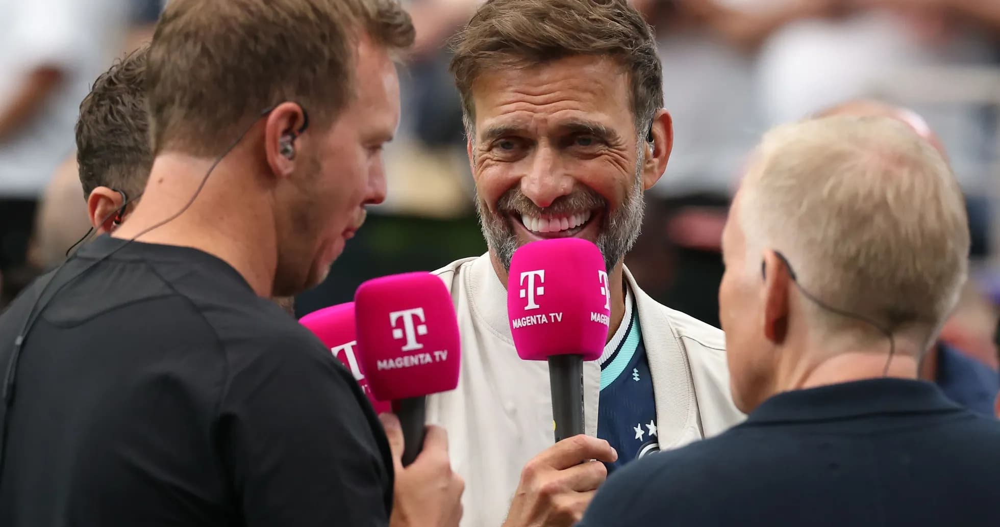 Three broadcasters holding microphones during an interview Three broadcasters holding microphones during an interview