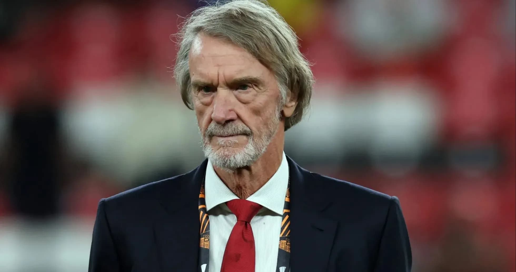 Man in suit with red tie at sports event Man in suit with red tie at sports event