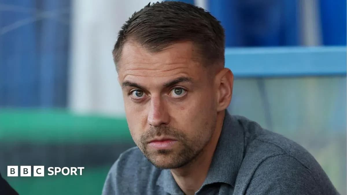 Man with short hair sitting in a sports setting Man with short hair sitting in a sports setting